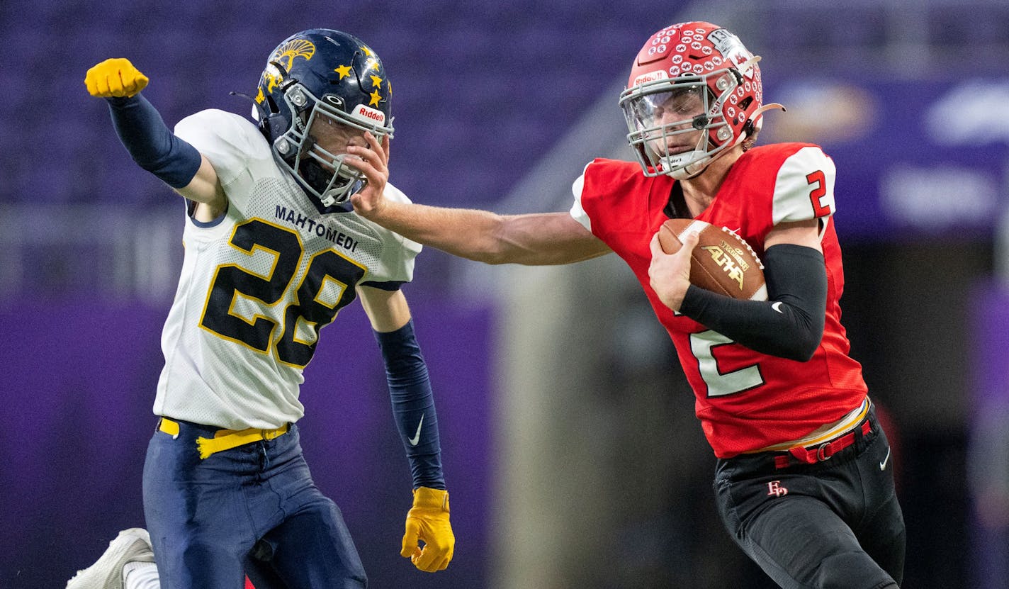 Elk River quarterback Cade Osterman (2) stiff arms Mahtomedi defensive back Nicholas Rollinger (28) in the third quarter of a Class 5A semi-final game Friday, Nov. 18, 2022 at U.S. Bank Stadium in Minneapolis. ]