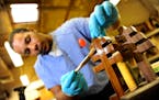 Inmate Hakiem Burke applies vanish to a cross that is part of a chair carved out of walnut for Pope Francis to use during his planned visit to the pri