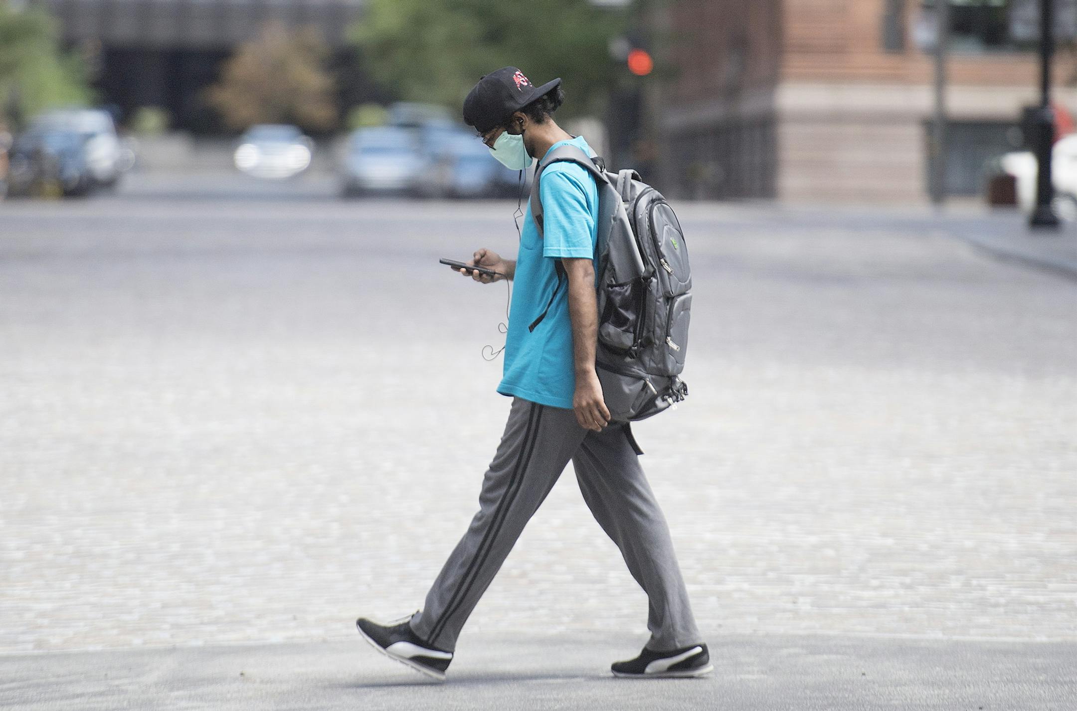 A man wears a face mask as he walks along a street in Montreal, Sunday, July 26, 2020, as the COVID-19 pandemic continues in Canada and around the world. (Graham Hughes/The Canadian Press via AP)