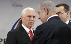 United States Vice President Mike Pence, left, speaks to Israeli Prime Minister Benjamin Netanyahu during a conference on Peace and Security in the Mi
