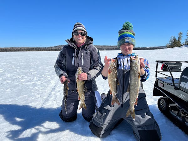 Sarah Strommen, DNR commissioner, with her son, Will, lake trout fishing near the BWCA in March 2022