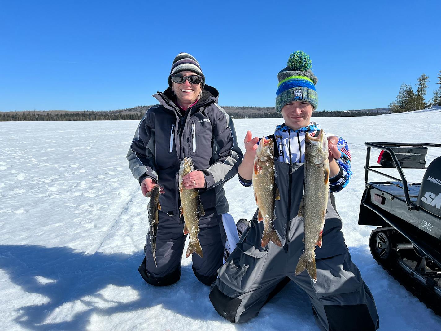 Sarah Strommen, DNR commissioner, with her son, Will, lake trout fishing near the BWCA in March 2022