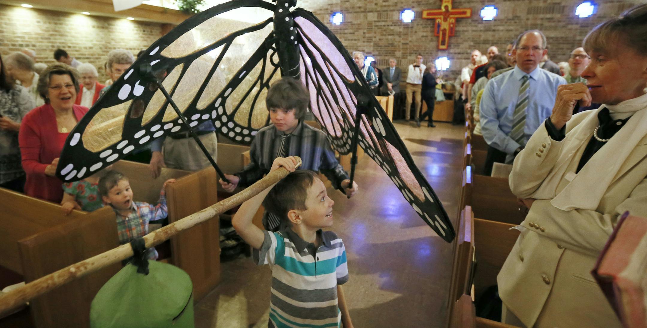 Andrew Beck (front} and Connor Korsmo carried a paper mache monarch butterfly down the the isle at Minnehaha United Methodist during Sunday morning Easter services.