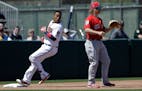 Minnesota Twins' Jorge Polanco, left, goes into third base ahead of the throw to Boston Red Sox's Brock Holt after hitting a triple off Red Sox pitche