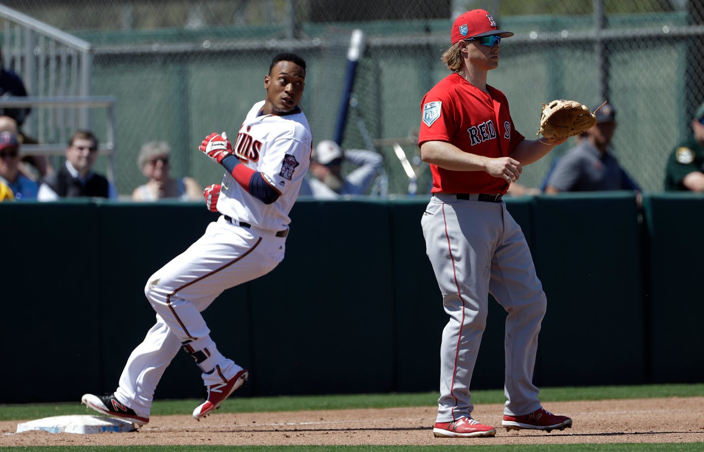 Minnesota Twins' Jorge Polanco, left, goes into third base ahead of the throw to Boston Red Sox's Brock Holt after hitting a triple off Red Sox pitcher Chris Sale during the fourth inning of a spring training baseball game Wednesday, March 14, 2018, in Fort Myers, Fla. (AP Photo/Chris O'Meara)