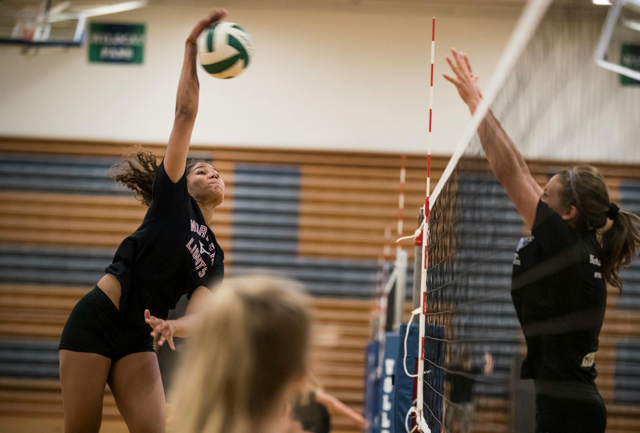 Kennedi Orr went for a kill while teammate McKenna Melville tried to block during the first day of volleyball practice at Eagan on Monday.