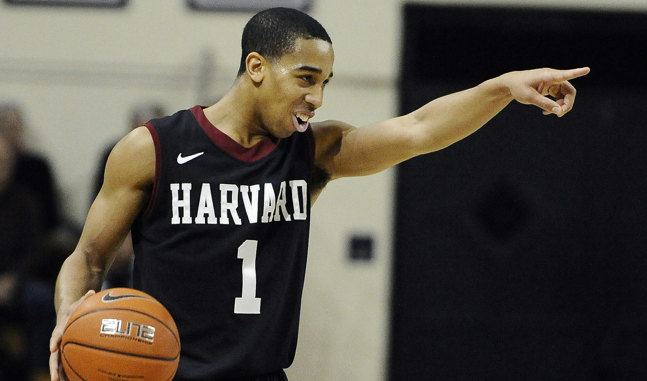 Harvard's Siyani Chambers, points and smiles at his team as he dribbles in the final seconds of an NCAA college basketball game against Yale, Friday, March 7, 2014, in New Haven, Conn. Harvard won 70-58. (AP Photo/Jessica Hill) ORG XMIT: CTJH110