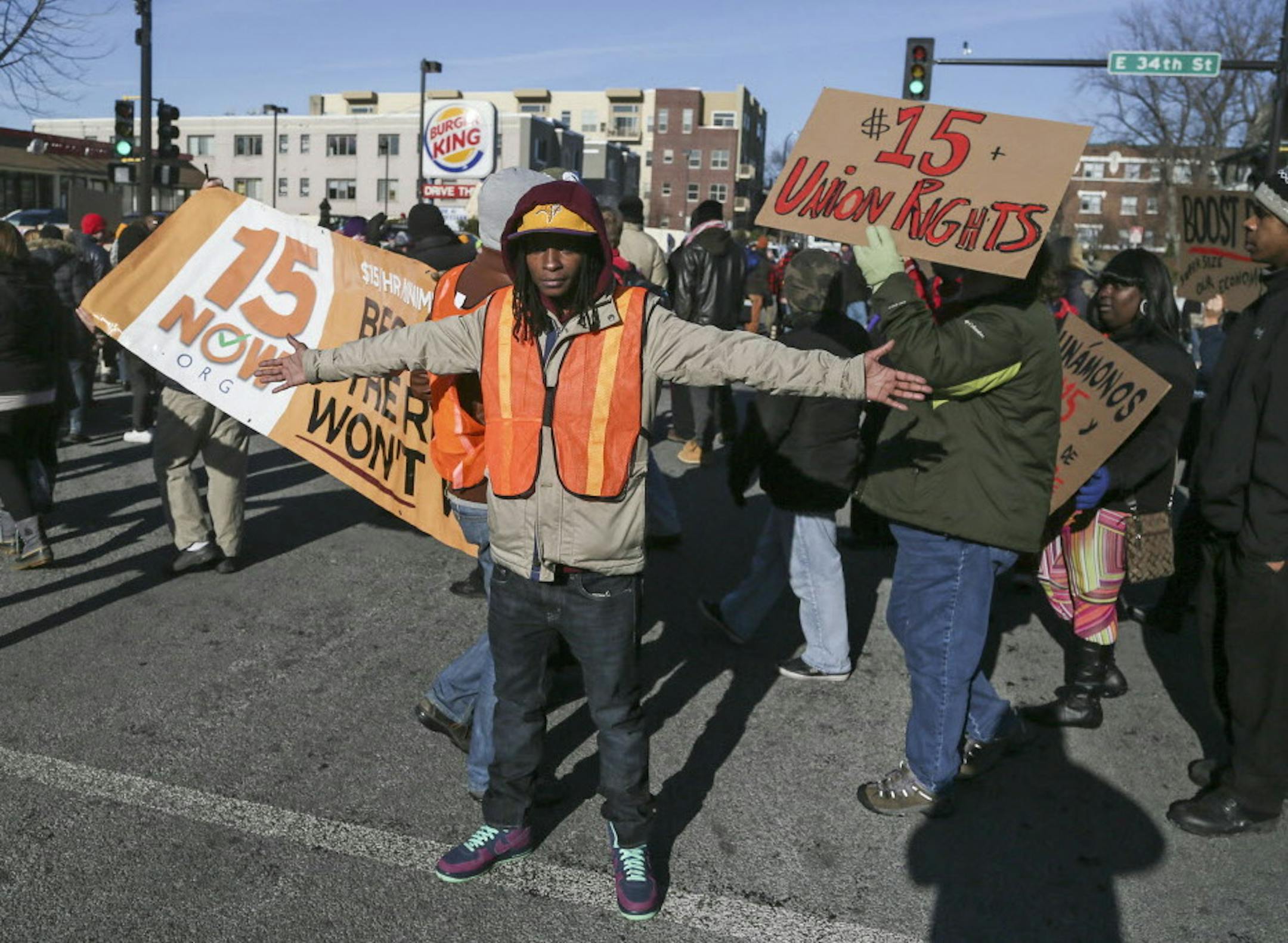 A protest against low wages for fast food employees at Burger King at 34th and Nicollet morphed into a larger protest against police treatment of young black males and moved to shutdown I-35W northbound from 35th Street as protestors marched to City Hall. Here, Shola Collins protects protestors outside Burger King from traffic Thursday, Dec. 4, 2014.](DAVID JOLES/STARTRIBUNE)djoles@startribune.com A protest that started out with Minneapolis Mayor Betsy Hodges joining fast food workers striking f