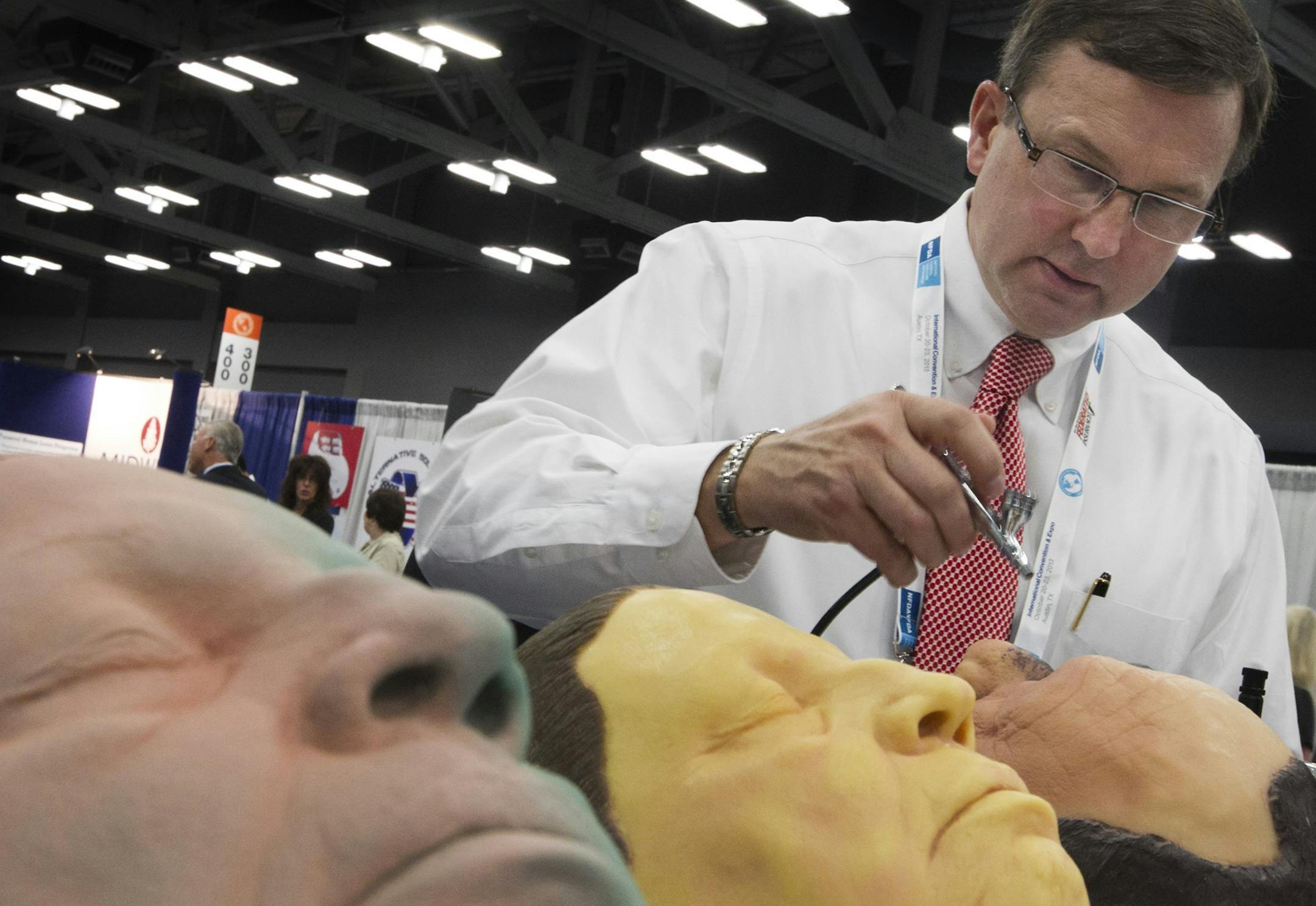 Chris Grimsley demonstrates his company's airbrush at the National Funeral Directors Association International Convention and Expo in Austin, Texas, on Oct. 22, 2013. (Jay Janner/Austin American-Statesman/MCT) ORG XMIT: 1144758