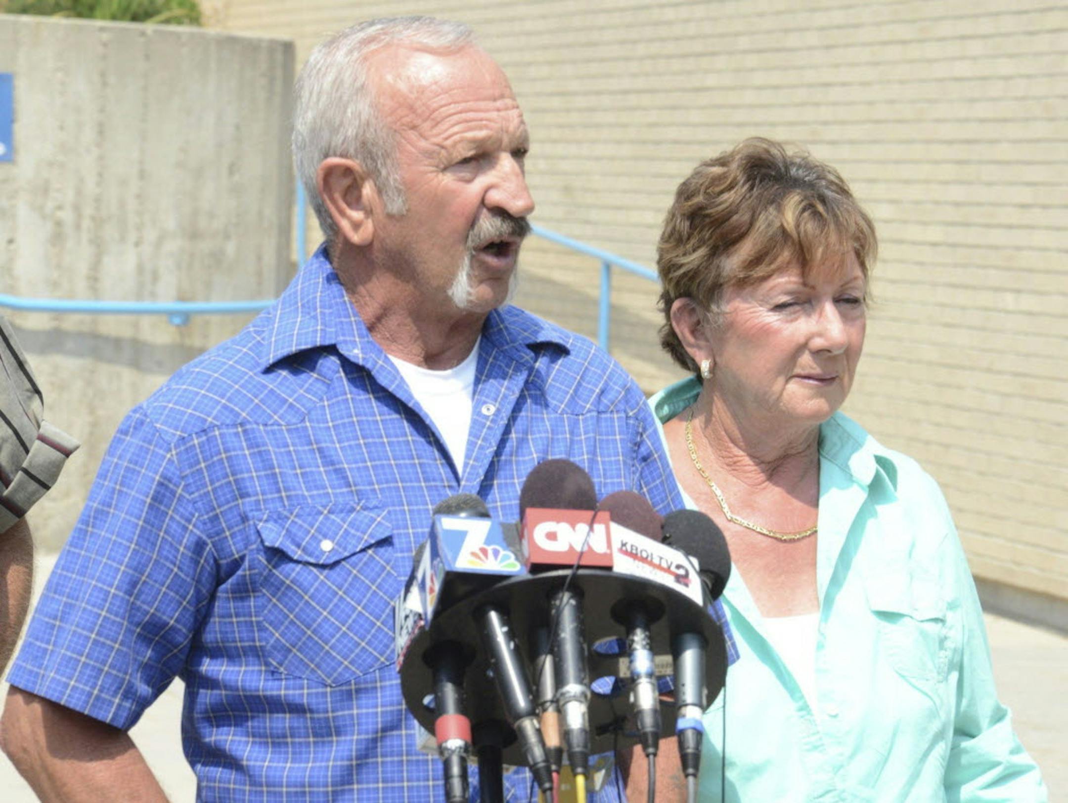 Mark John, standing with wife, Christa John, talk to the media at the Ada County Sheriff's Office in Boise, Idaho.