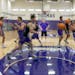 St. Thomas Head Coach Johnny Tauer, center, watches over a passing drill during practice at St. Thomas University in St. Paul, Minn., on Thursday, Jul