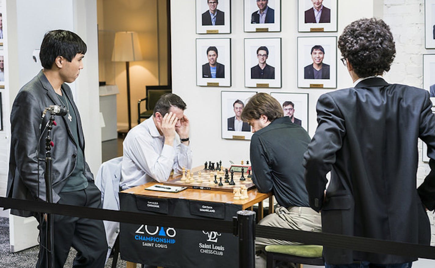 Wesley So, left, checks the position on the board as Sam Shankland (seated, with dark shirt) plays in the next to last round of the U.S. Chess Championship at the St. Louis Chess Club.