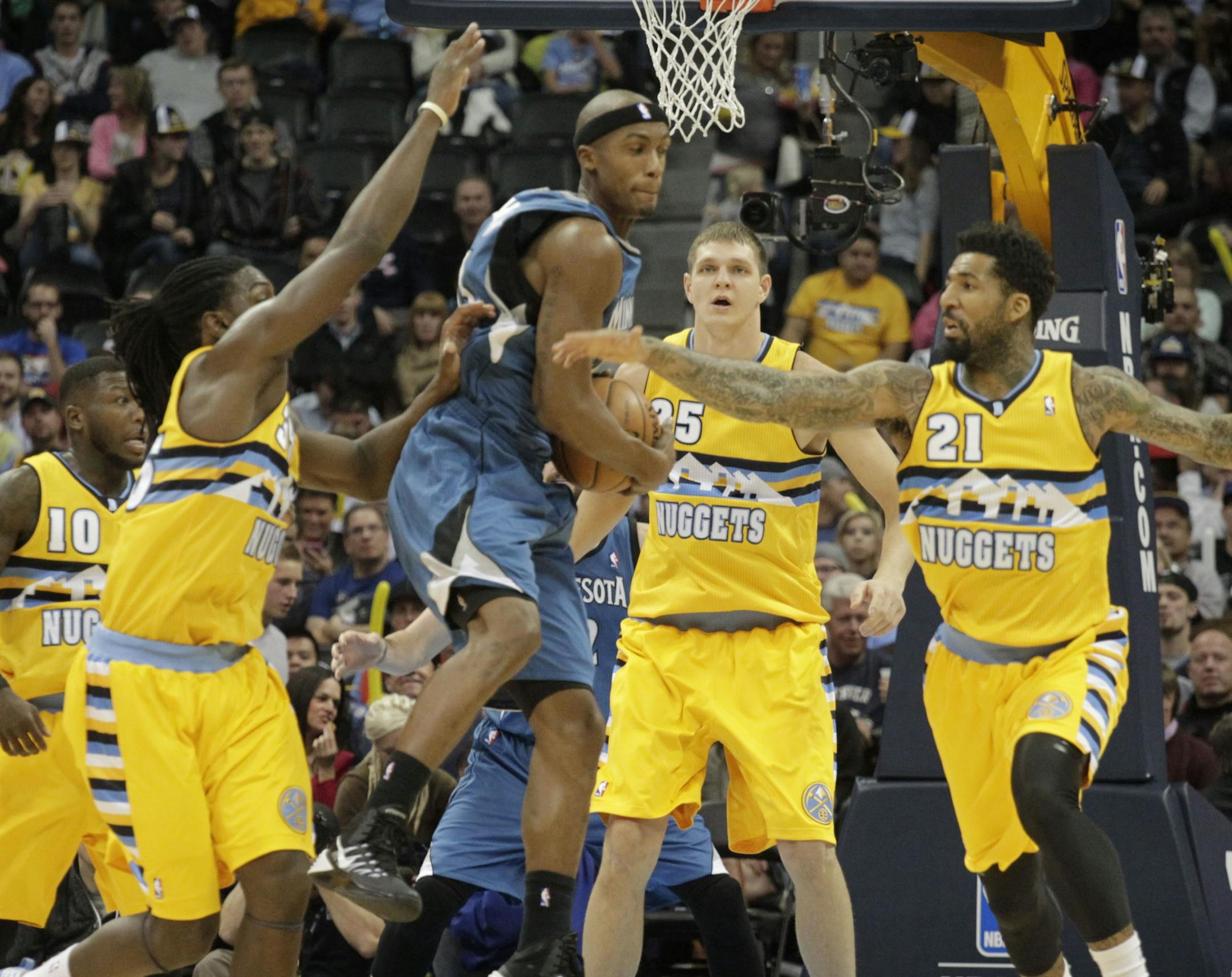 Minnesota Timberwolves forward Corey Brewer, third from left, scoops up a loose ball against Denver Nuggets forwards Kenneth Faried (35) and Wilson Chandler (21) as Nuggets center Timofey Mozgov (25) backs up the play during the first quarter of an NBA basketball game in Denver, Friday, Nov. 15, 2013. (AP Photo/Joe Mahoney)