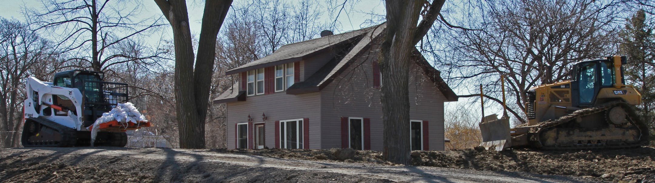 One of the few remaining homes in the Oak Grove neighborhood in Fargo, North Dakota stands behind a dike being built on South Terrace North on April 26, 2013. Many of the homes on the street have been removed, but several remain. ] SHARI L. GROSS‚Ä¢ sgross@startribune.com