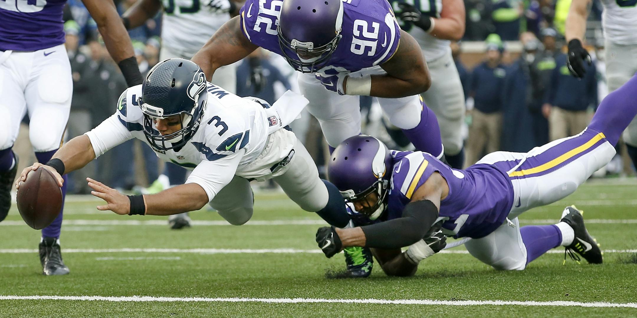Seattle quarterback Russell Wilson (3) got past Tom Johnson (92) and Antone Exum Jr. (32) to score a touchdown in the second quarter.
