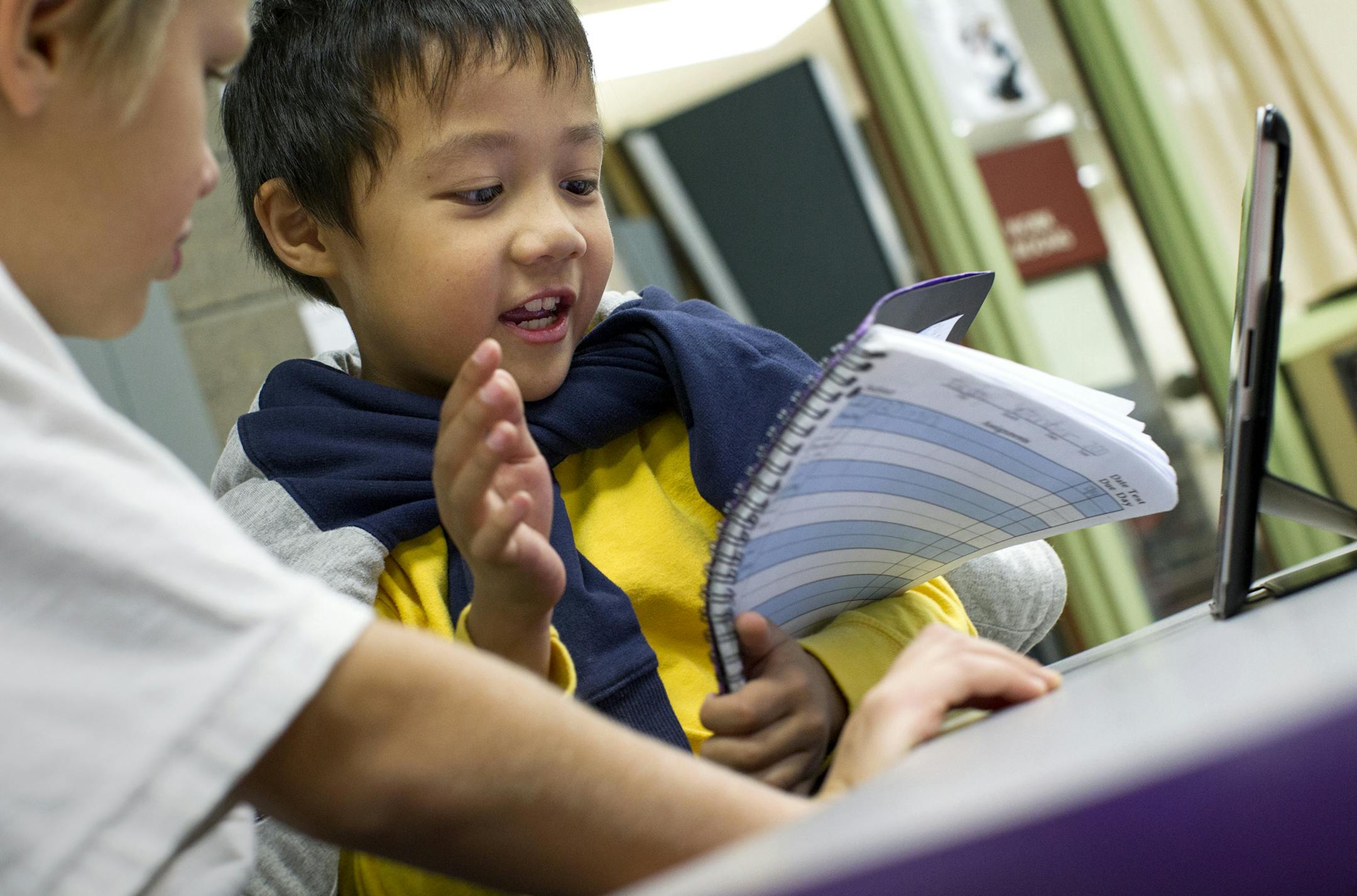 Third grade student Tien Cao, 8, works with a classmate to access a book to read on a classroom iPad at Impact Academy, a separate school program within Orchard Lake Elementary School in Lakeville October 8, 2013. Students often help teach one another in the specialized learning environment. ORG XMIT: MIN1310091411363537