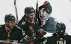 Minnesota Wild's Zach Parise celebrates with his arm around teammate goalie Alex Stalock after Stalock won the game 3-2 in a shootout against the Dall