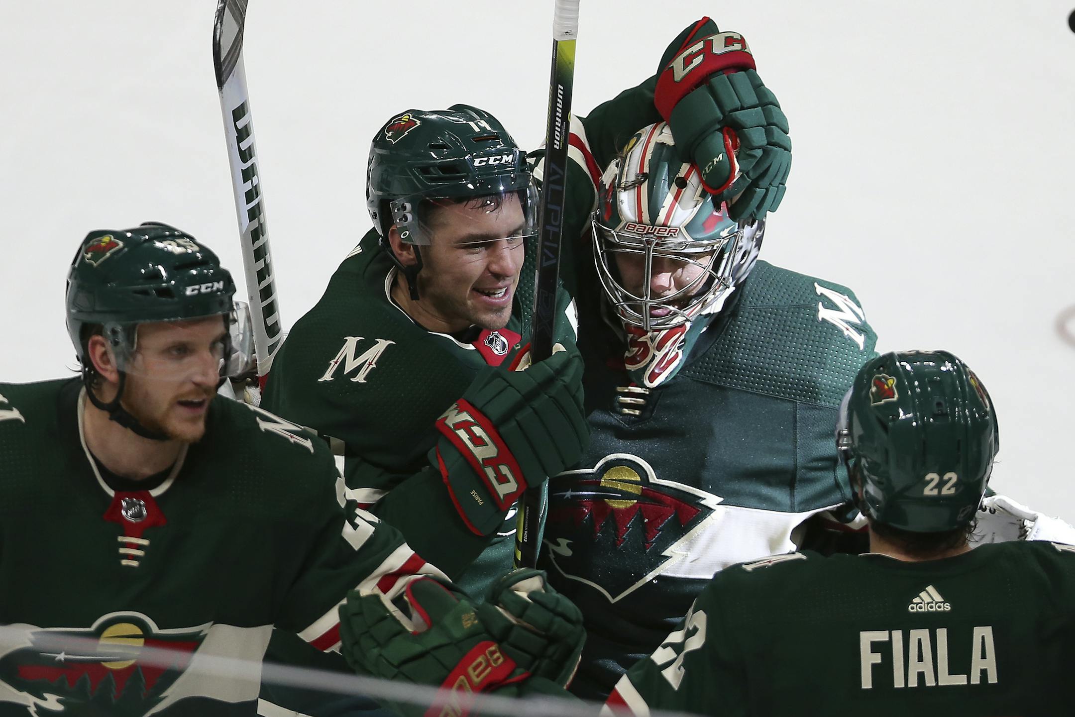Minnesota Wild's Zach Parise celebrates with his arm around teammate goalie Alex Stalock after Stalock won the game 3-2 in a shootout against the Dallas Stars during an NHL hockey game Sunday, Dec. 1, 2019, in St. Paul, Minn. (AP Photo/Stacy Bengs)