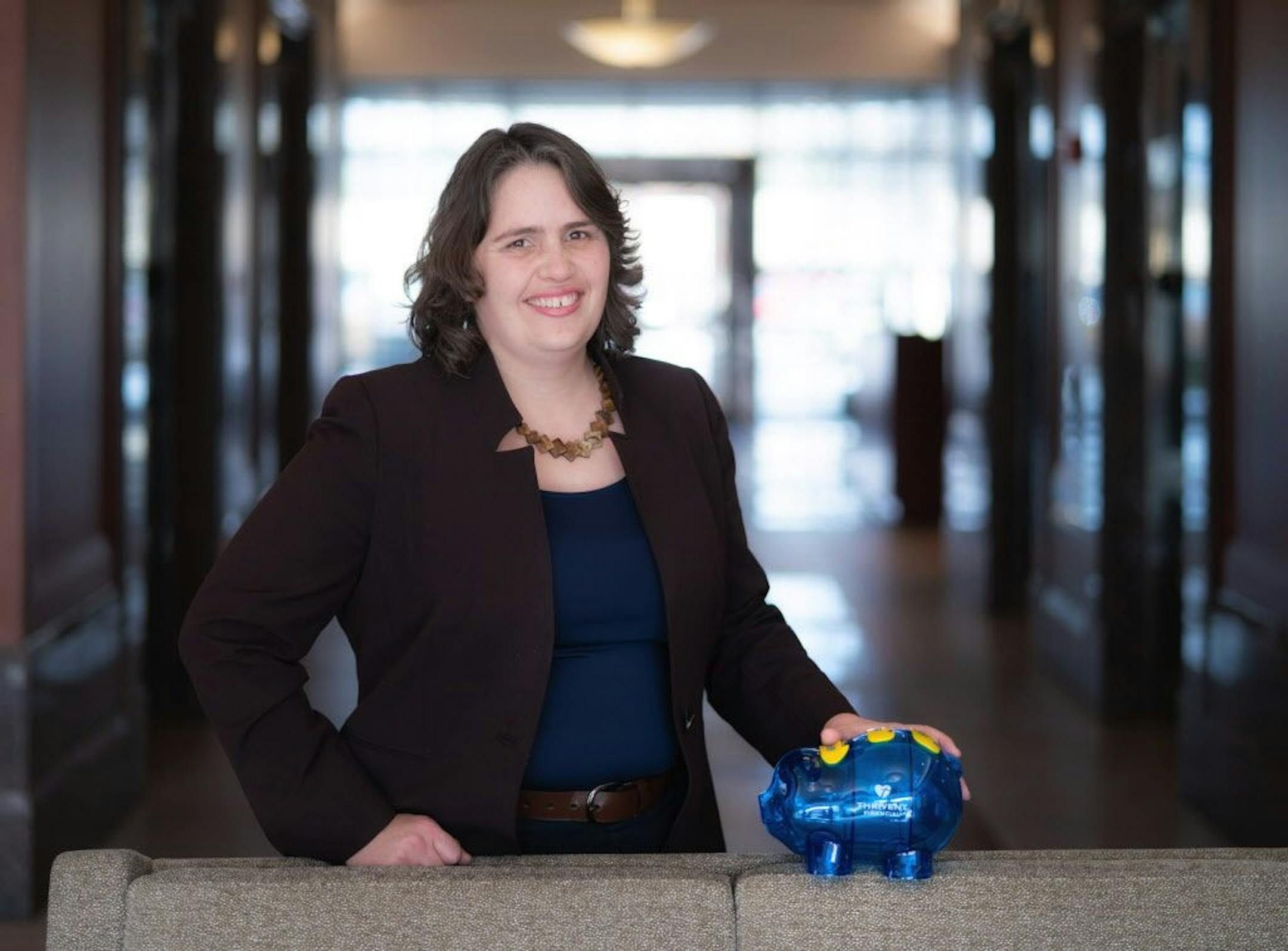 Marcia Alexander is going to help parents survive the holidays by teaching their kids the value of money. She is holding a blue piggy bank that helps kids save.