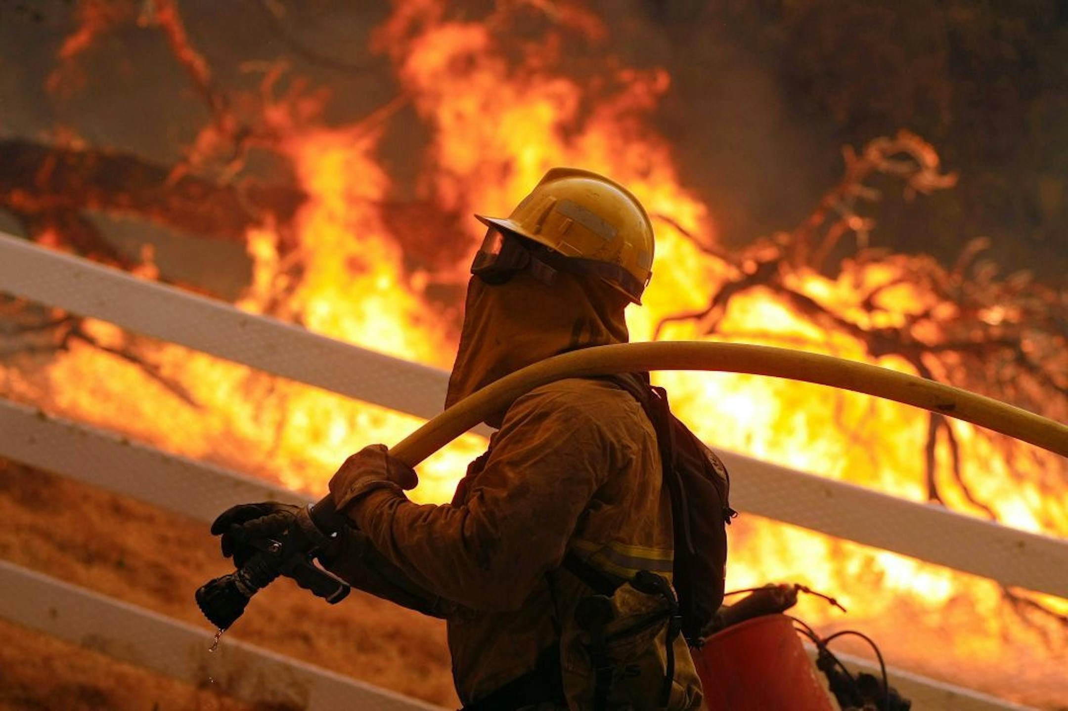 A firefighter from Stockton, Calif., gets into position to put out flames off of Hidden Valley Rd. while fighting a wildfire, Friday, May 3, 2013 in Hidden Valley, Calif. A huge Southern California wildfire burned through coastal wilderness to the beach on Friday then stormed back through canyons toward inland neighborhoods when winds reversed direction. (AP Photo/Los Angeles Times, Mel Melcon) NO FORNS; NO SALES; MAGS OUT; ORANGE COUNTY REGISTER OUT; LOS ANGELES DAILY NEWS OUT; VENTURA COUNTY S