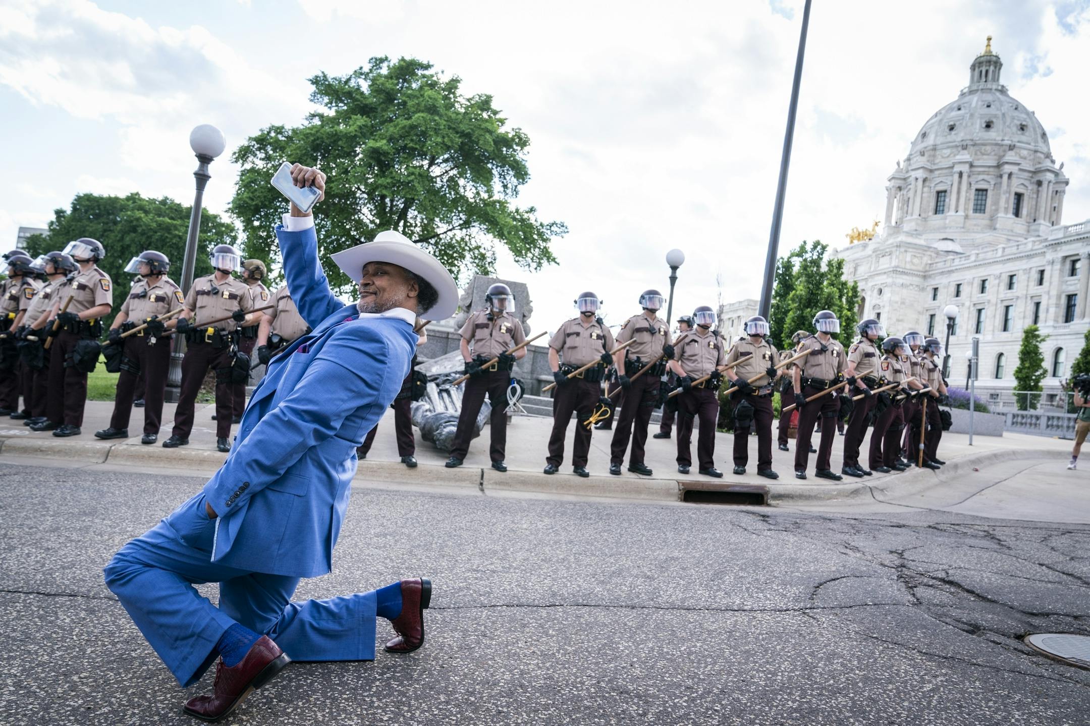 Ricky Jones of Minneapolis posed for a photo in front of the toppled Christopher Columbus statue, which was surrounded by Minnesota State Troopers.