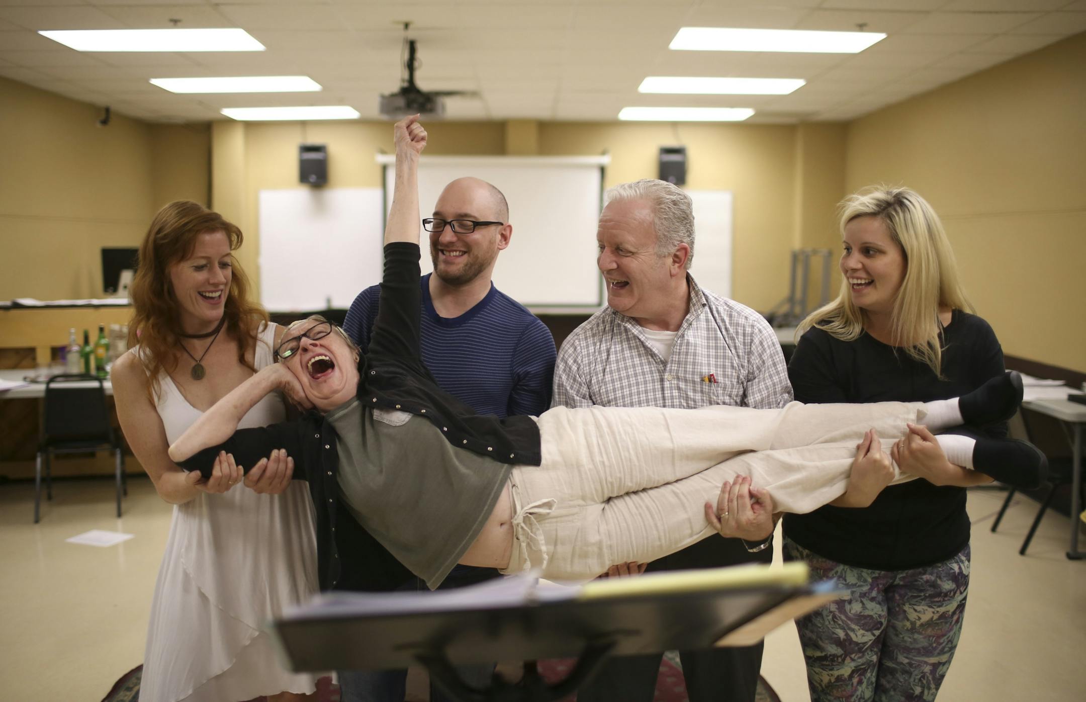 Sandra Struthers, Adam Qualls, Gary Briggle, and Ruthie Baker, from left, lifted Wendy Lehr at the end of a scene where she played a lawyer during rehearsal Wednesday night.