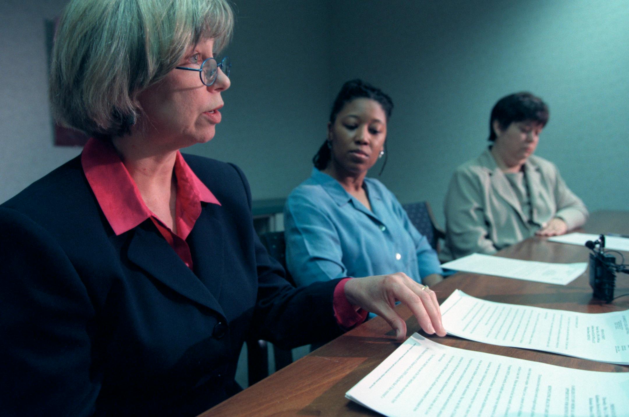 Kathleen Davis of Legal Aid Society of Minneapolis, left, and Ralonda Mason of Mid-Minnesota Legal Aid, far right, speak at a news conference May 3, 2001, concerning women who were incorrectly cut off medical assistance.