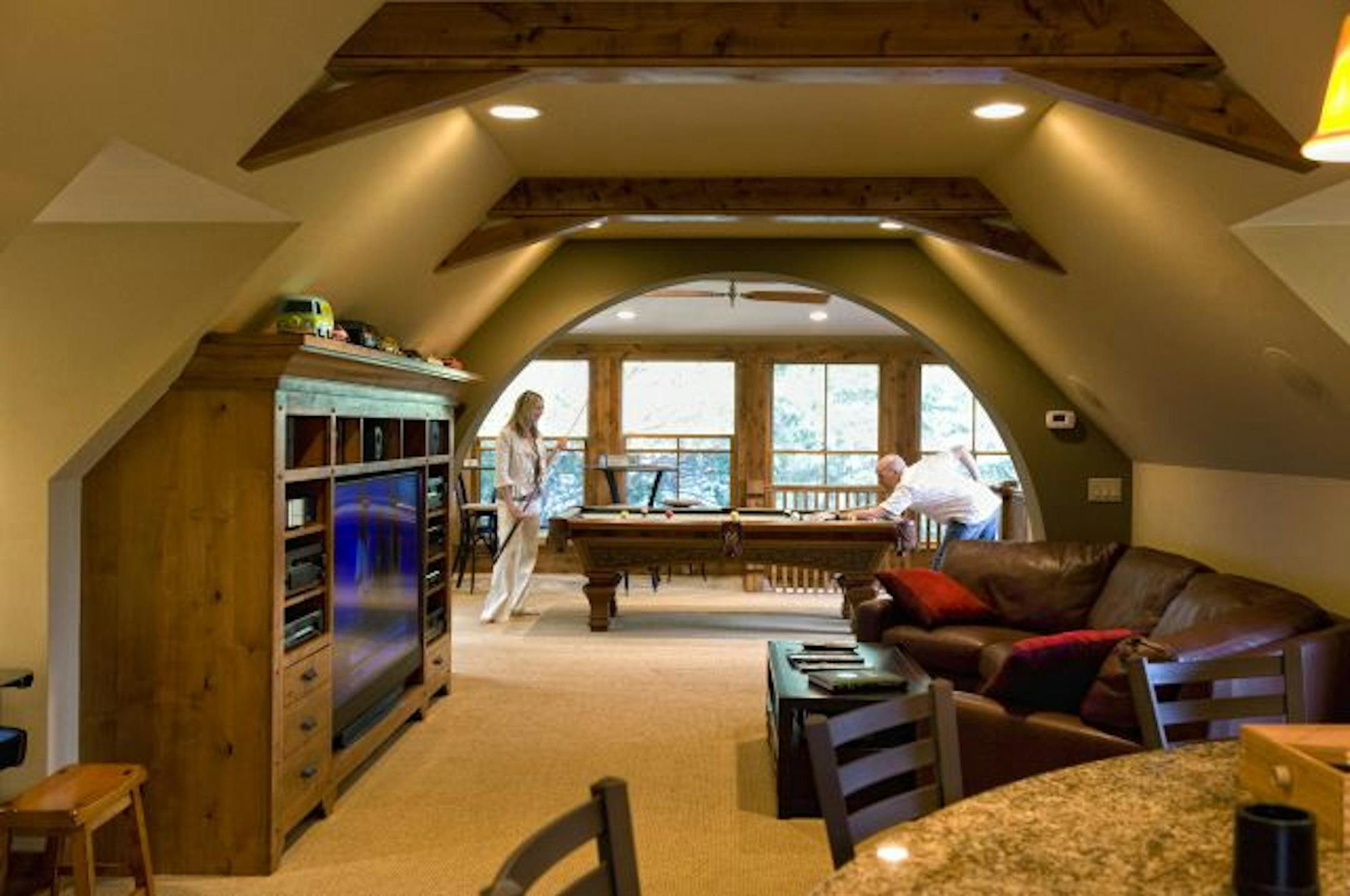 Jeff Murphy and his wife Jill hit some pool balls in the upper level of the garage. Jeff Murphy desined and built his home away from home with two levels, rec room, bar, work area for his motorized toys adjacent to his home on Buffalo Lake.