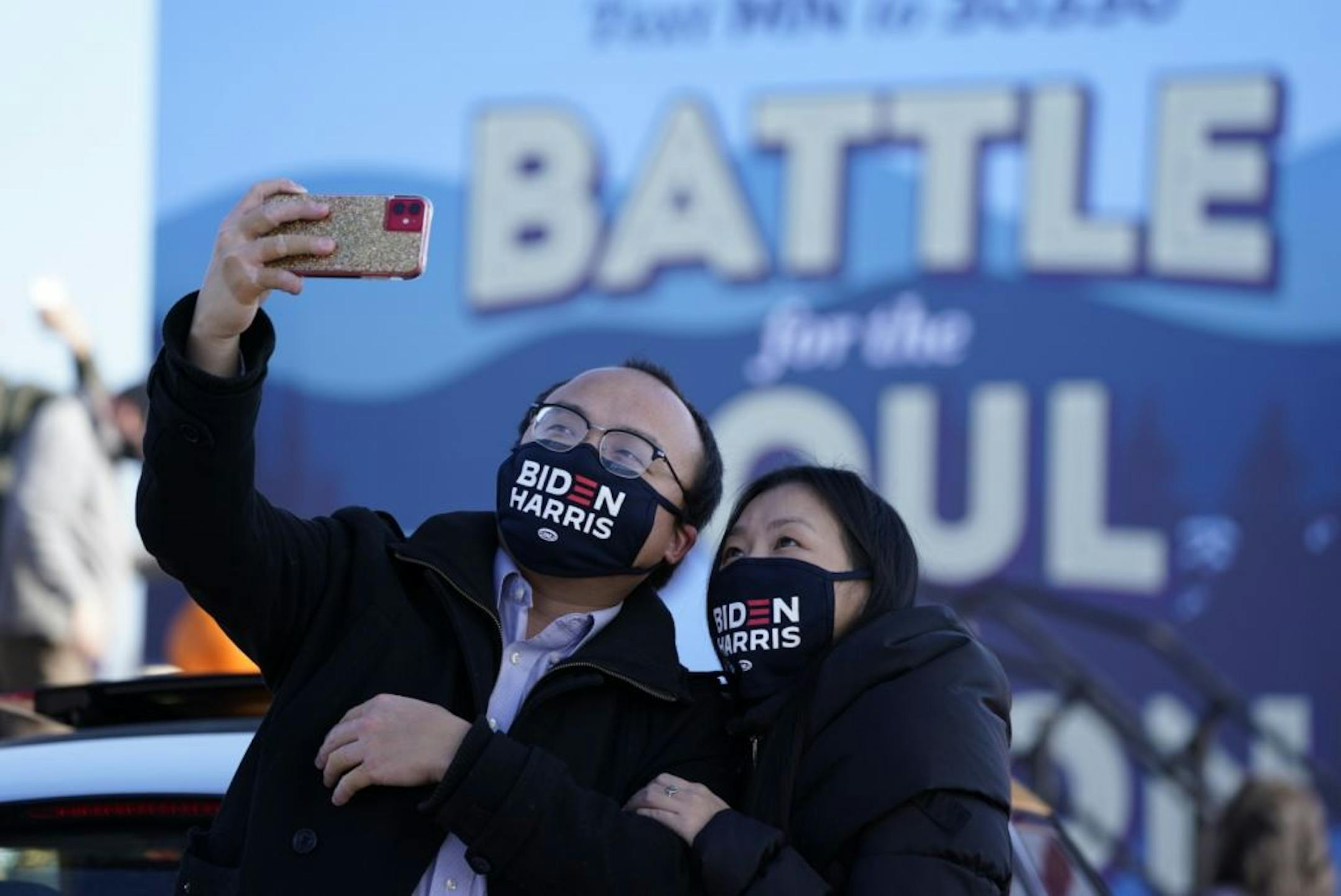Souvan Lee, left, and his girlfriend Hnuchee Vang, both of Richfield, took selfies before former Vice President Joe Biden spoke during a drive-in campaign event in Falcon Heights.