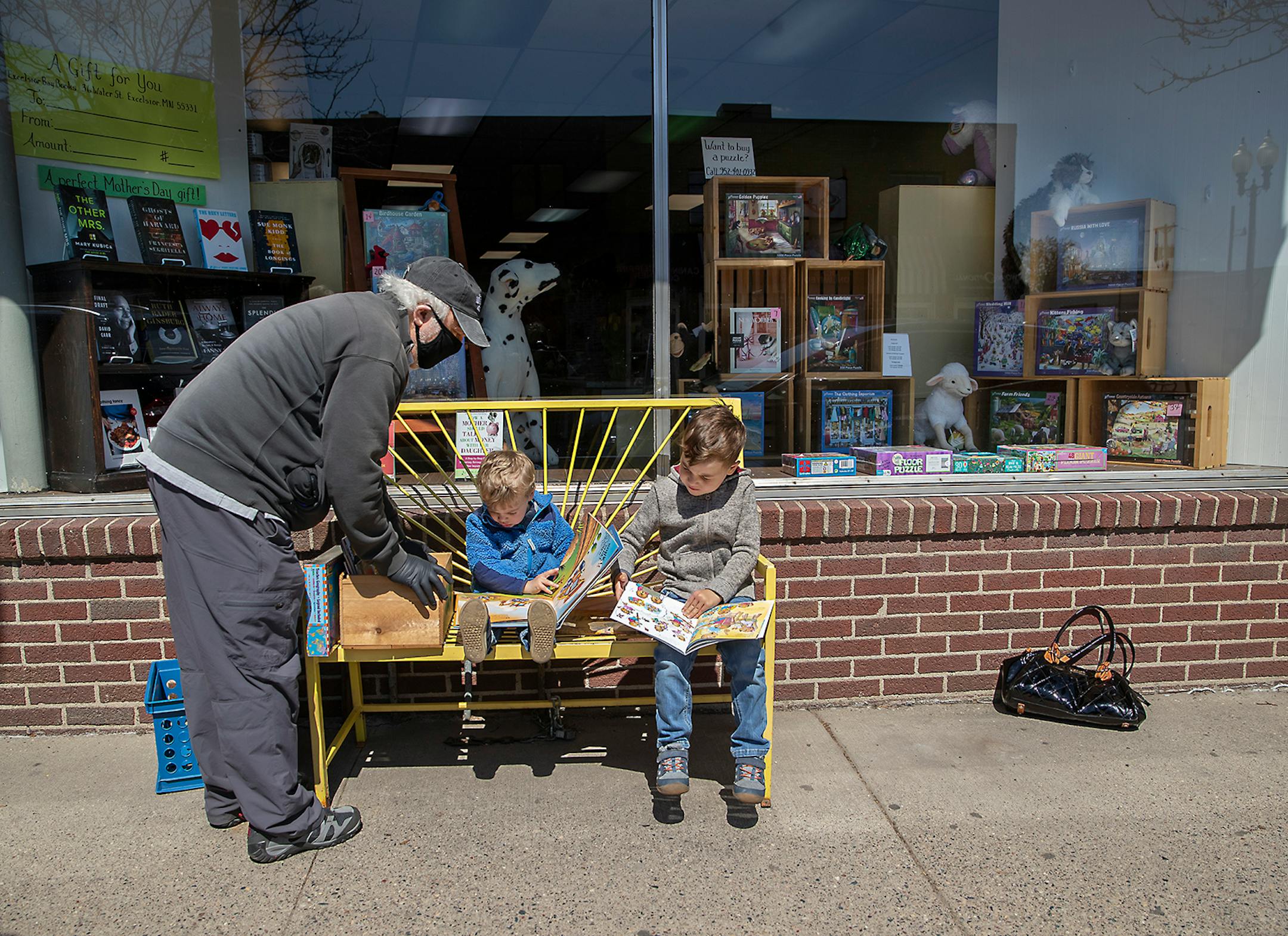 Bill Friedrich looked through books with his grandsons Will, 2, center, and Sully, 5, at Excelsior Bay Books, Monday, May 11, 2020 in Excelsior, MN. When a longtime employee, Ann Woodbeck of Excelsior Bay Books bought the store in January, little did she know a crisis would hit less than three months later, leaving her not knowing how she'd pay the bills. The store raised about $17,000 in a GoFundMe page, but discontinued it early because community support was so strong. Now she has a thriving b