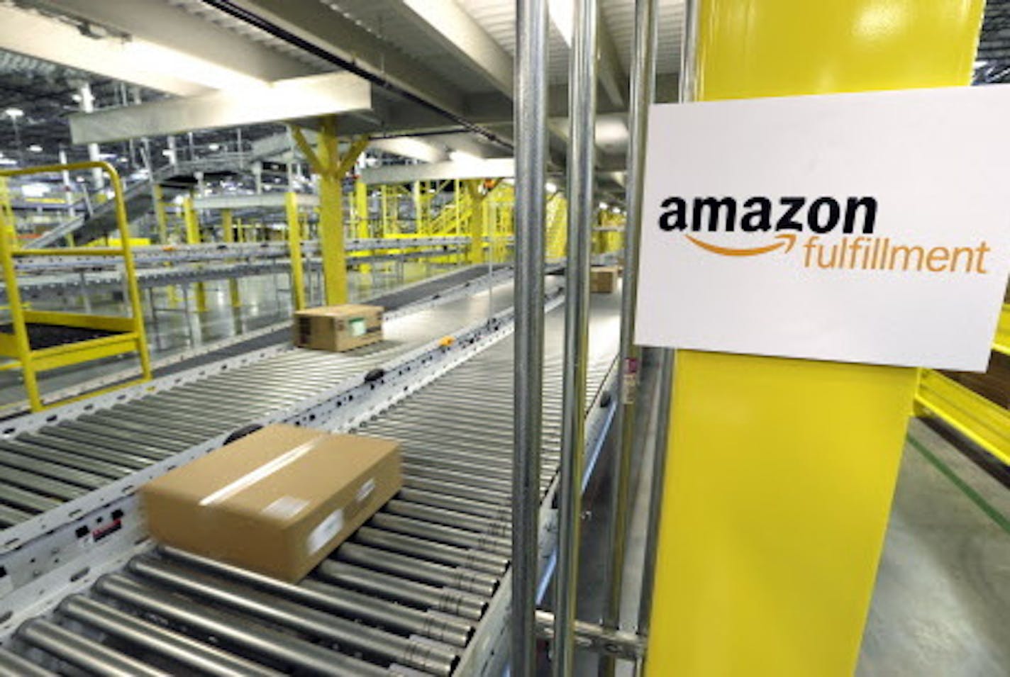 FILE - In this Feb. 13, 2015, file photo, a package moves along a conveyer belt during a media tour of the Amazon.com fulfillment center in DuPont, Wash. Amazon.com reports quarterly financial results Thursday, Jan. 28, 2016. (AP Photo/Ted S. Warren, File)