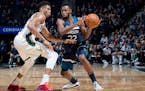 The Wolves' Andrew Wiggins (being guarded by the Bucks' Giannis Antetokounmpo on Monday night) is averaging 21.2 points per game, almost two points hi