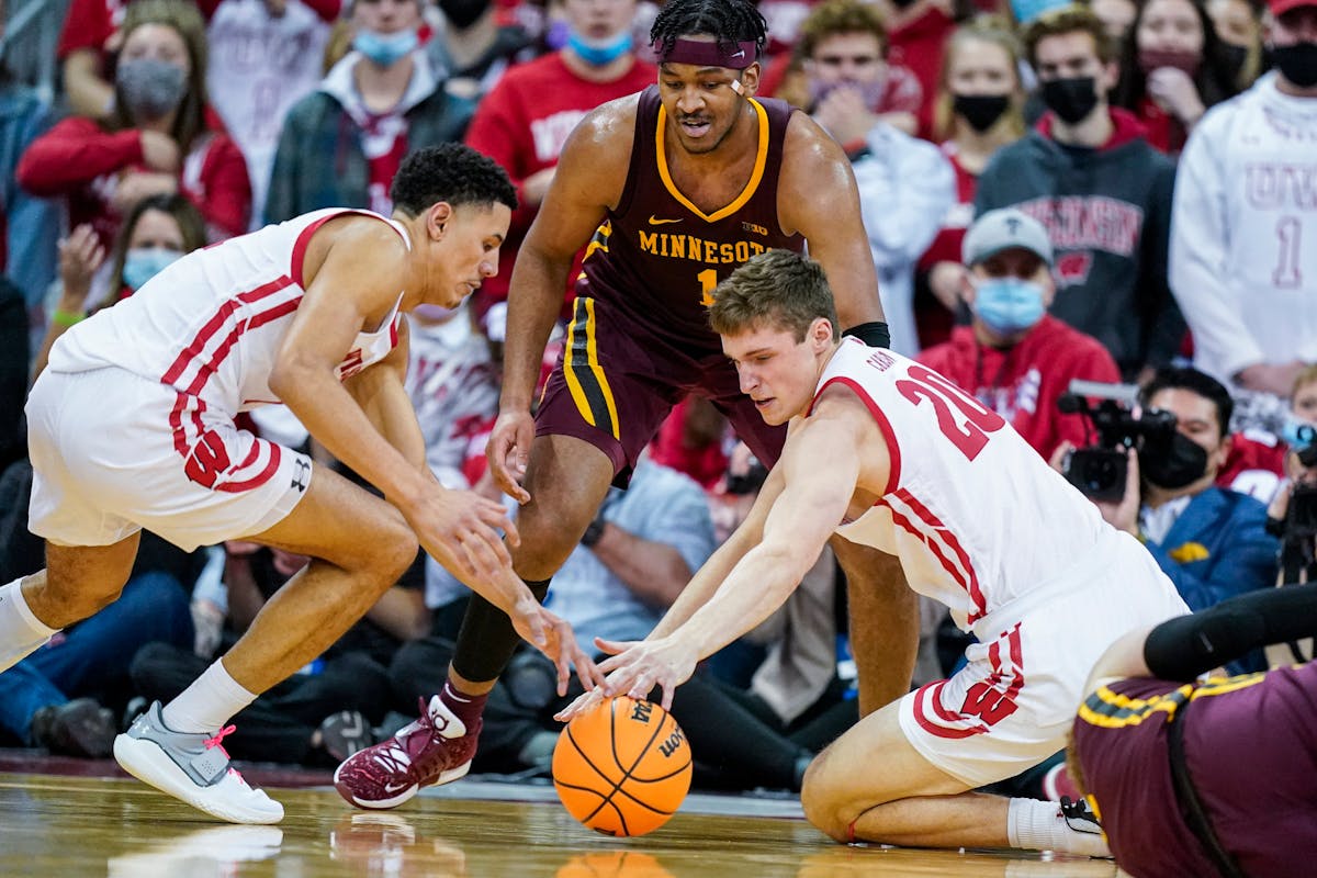 The Gophers’ Eric Curry, center, battled for a loose ball with Wisconsin’s Johnny Davis, left, and Ben Carlson in the second half Sunday in Madiso