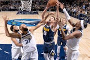 The Nuggets' Nikola Jokic goes up hard against Wolves center Rudy Gobert (27) in a November 2023 game.