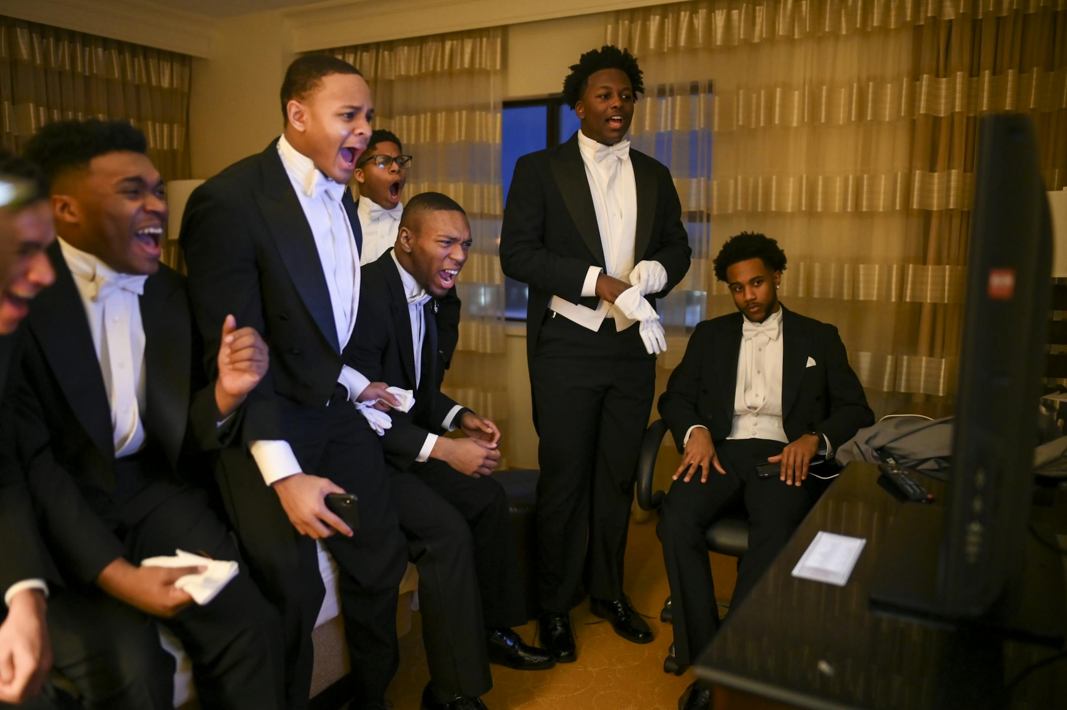 A group of junior escorts reacted to a dunk by Duke basketball star Zion Williamson as his team played NC State Saturday as they waited for the start of their cotillion ball in a hotel suite.
