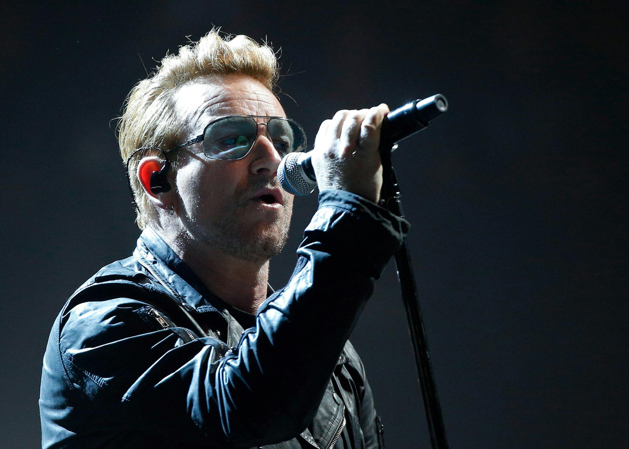 Bono of U2 performs on stage during a concert, in Paris, Sunday, Dec. 6, 2015. U2ís performance in Paris on Sunday night wasnít just about music _ it had a mournful tinge, too. Frontman Bono paid respects to 130 people killed by extremists in Paris on Nov. 13, and 14 people killed in a mass shooting last week in California. (AP Photo/Thibault Camus)