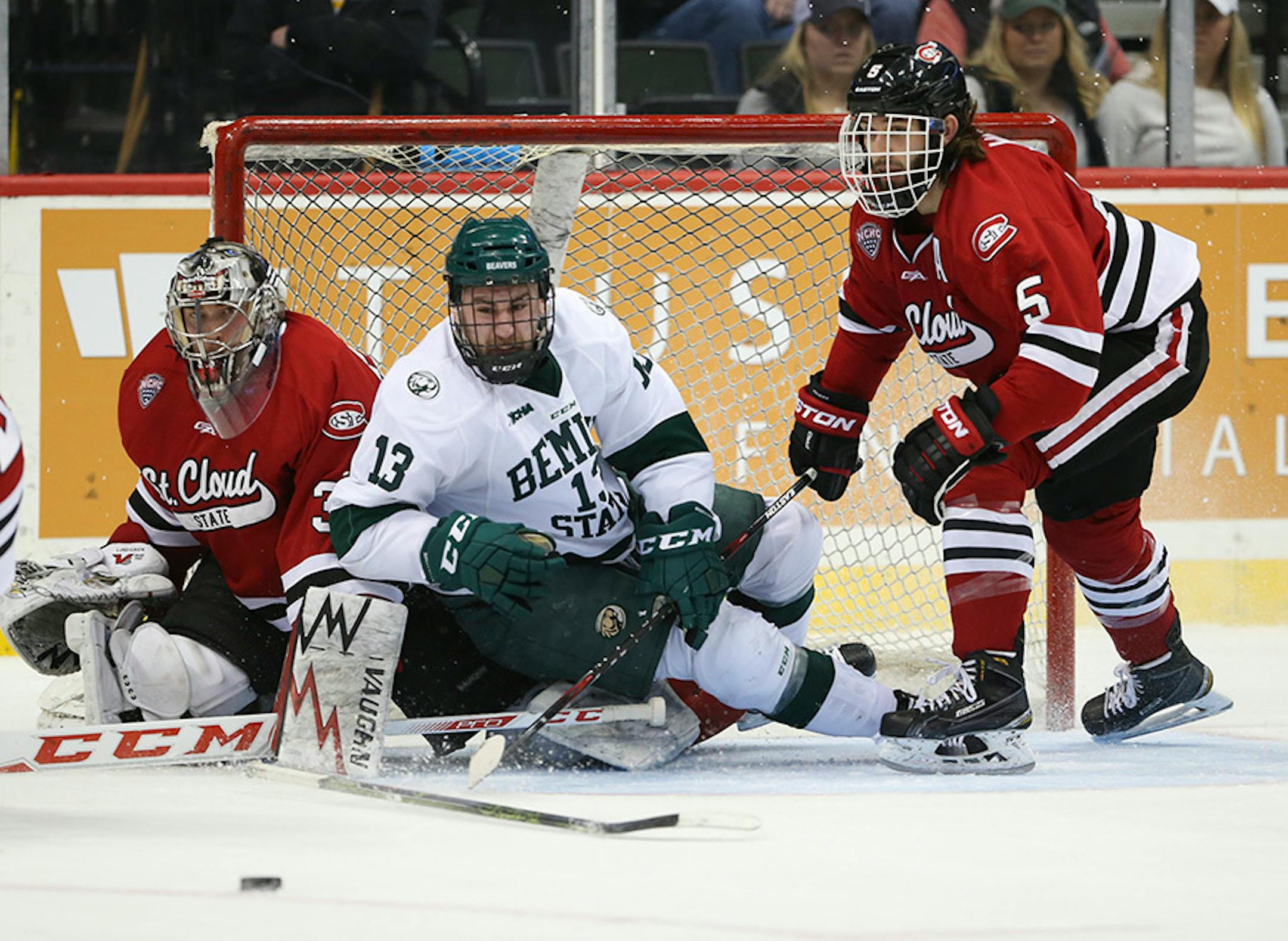Beavers forward Cory Ward (13) watched the puck slip out of reach after losing his stick when he was checked into St. Cloud goalie Charlie Lindgren (35) by Huskies defenseman Nathan Widman (5) in the second period Sunday afternoon.