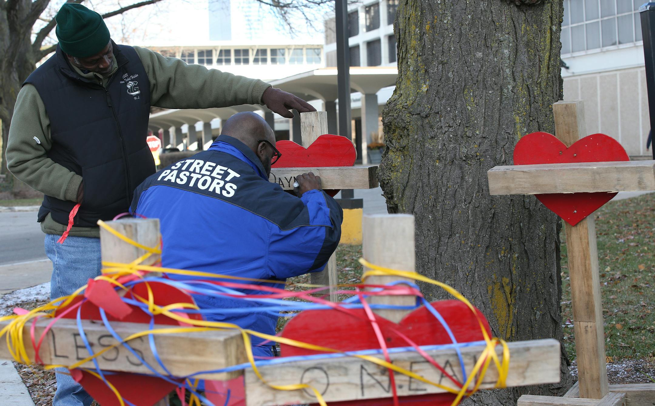 Ziff Sistrunk, left, and Donovan Price, place crosses at Chicago Mercy Hospital to remember the shooting victims on November 20, 2018. (Antonio Perez/Chicago Tribune/TNS)