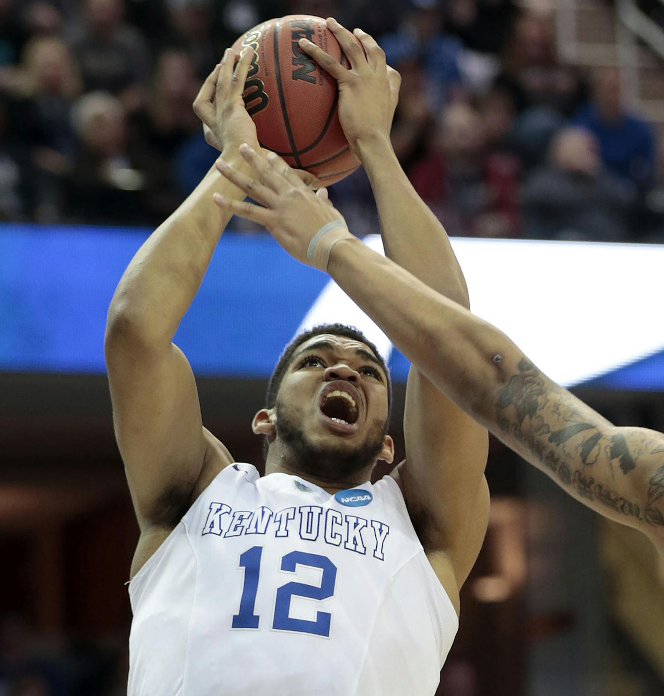 Kentucky's Karl-Anthony Towns (12) scores against Notre Dame's Zach Auguste (30) in the first half in the NCAA Tournament's Elite 8 on Saturday, March 28, 2015, at Quicken Loans Arena in Cleveland. (Charles Bertram/Lexington Herald-Leader/TNS) ORG XMIT: 1165903