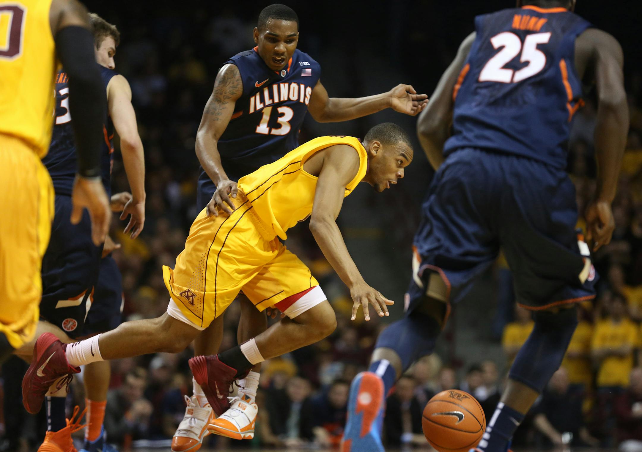 Andre Hollins got tripped up and fouled by Illinois Tracy Abrams during the first half at Williams Arena