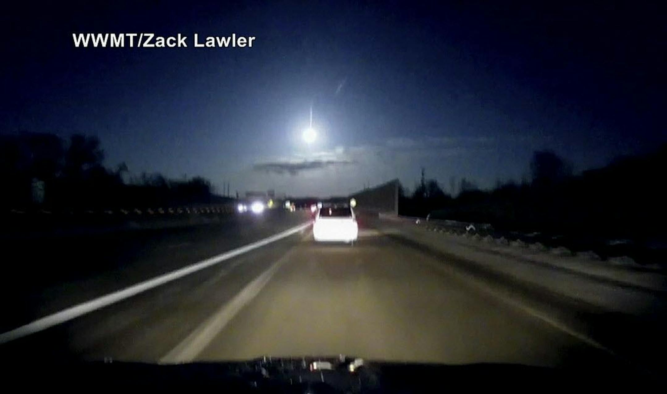 In this late Tuesday, Jan. 16, 2018, image made from dashcam video, a brightly lit object falls from the sky above a highway in the southern Michigan skyline.