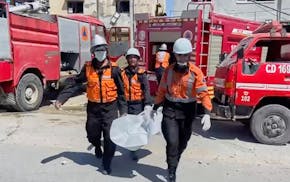 In this frame grab from a video released by Gaza Civil Defense, workers collect human remains after an Israeli strike on a home in Khan Younis killed