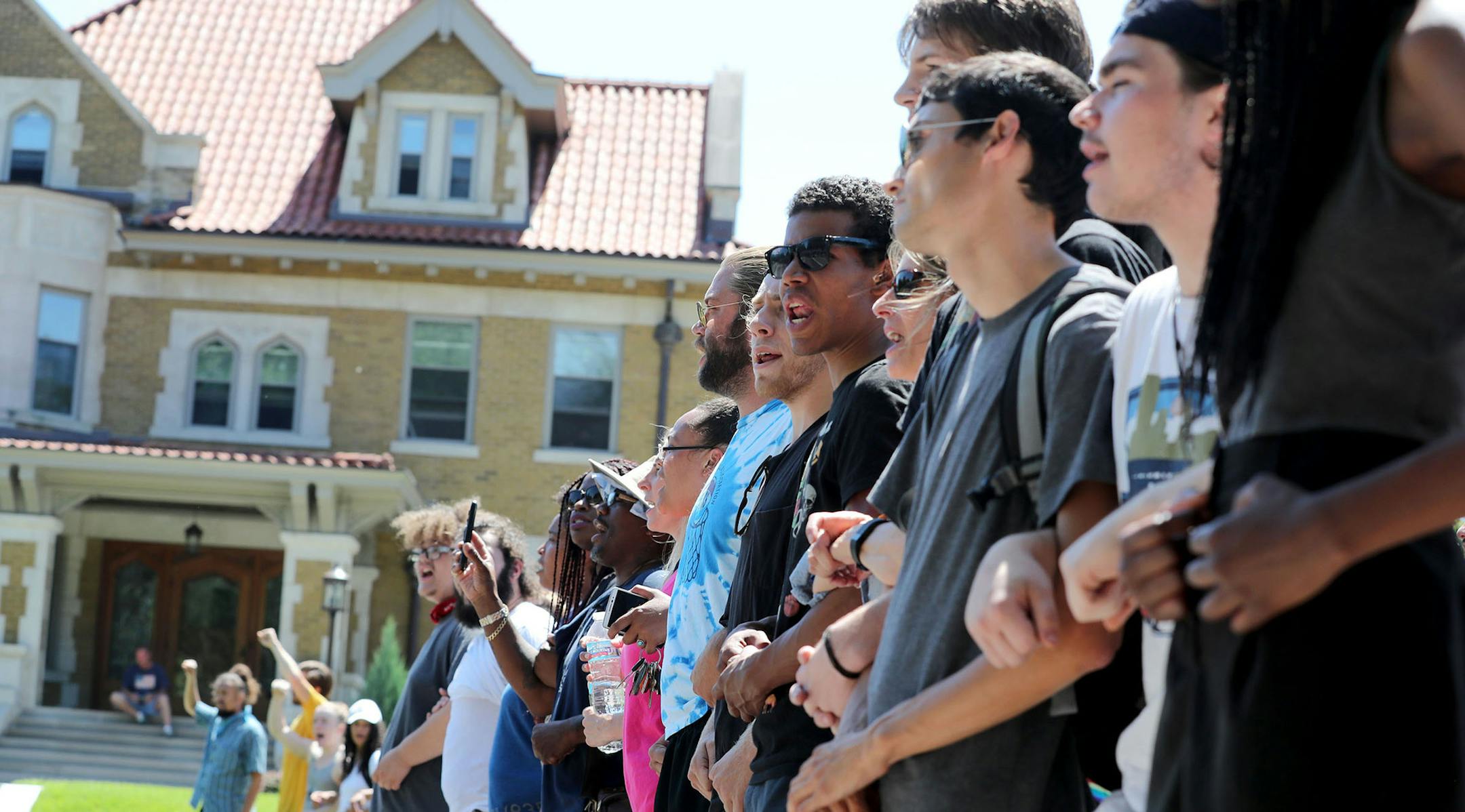 Protestors lock arms at Oxford and Summit while squaring off with police officers near Gov. Mark Dayton's mansion. Earlier police moved protestors from the spot and made arrests before protestors reclaimed their spot Tuesday, July 26, 2016, in front of St. Paul, MN. ](DAVID JOLES/STARTRIBUNE)djoles@startribune Protesters were ordered Tuesday to clear the street and sidewalk in front of the governor's residence, where they have been since the fatal police shooting of Philando Castile nearly three