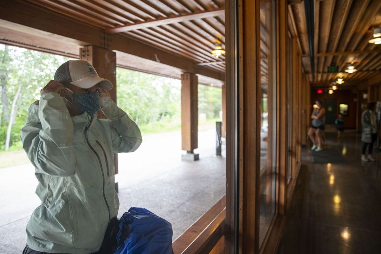 Crystal Gail Welcome put on a face mask before entering the Gooseberry Falls Visitor Center near Two Harbors, Minn. A statewide mask mandate is now in effect.