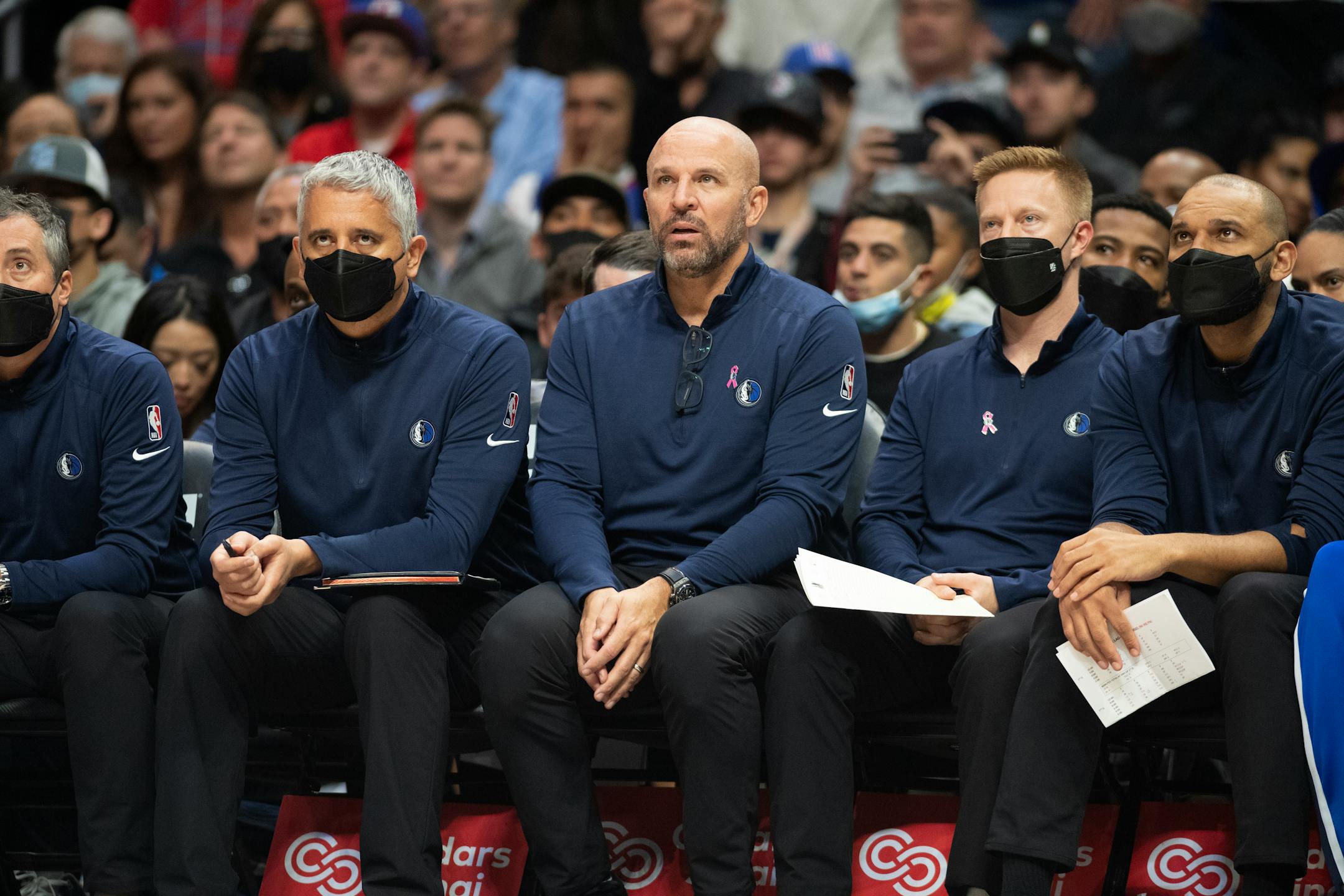 Dallas Mavericks head coach Jason Kidd sits with his assistants who are all wearing masks while playing the Los Angeles Clippers in an NBA basketball game, Tuesday, Nov. 23, 2021, in Los Angeles. (AP Photo/John McCoy)