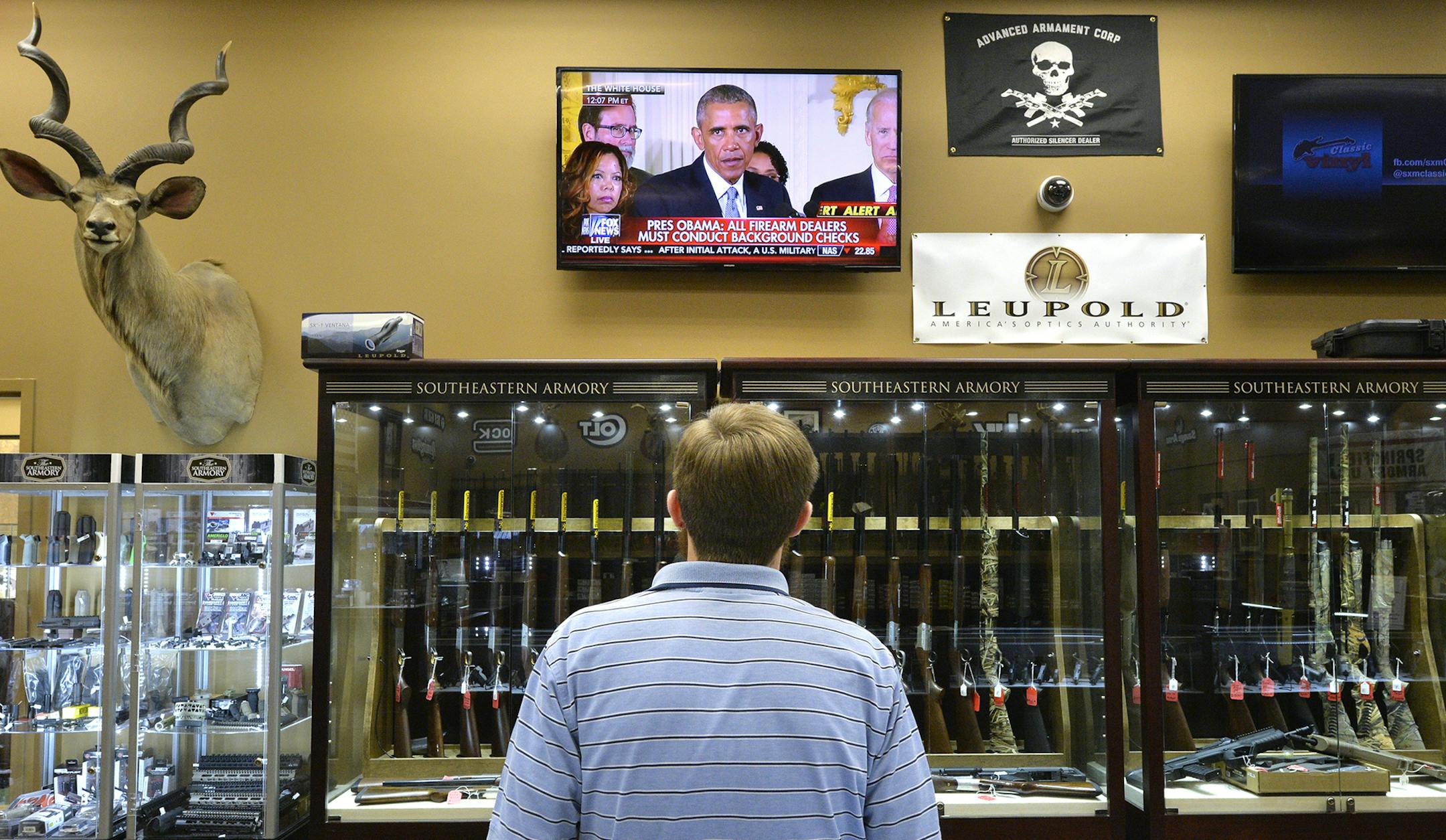 Brett Busbee, sales associate at Southeastern Armory, a gun store in Augusta, Ga., watches as President Obama speaks at the White House about his gun control measures Tuesday, Jan. 5, 2016. President Obama unveiled his plan Tuesday to tighten control and enforcement of firearms in the U.S. (Michael Holahan/Augusta Chronicle via AP) ORG XMIT: MIN2016010613331125