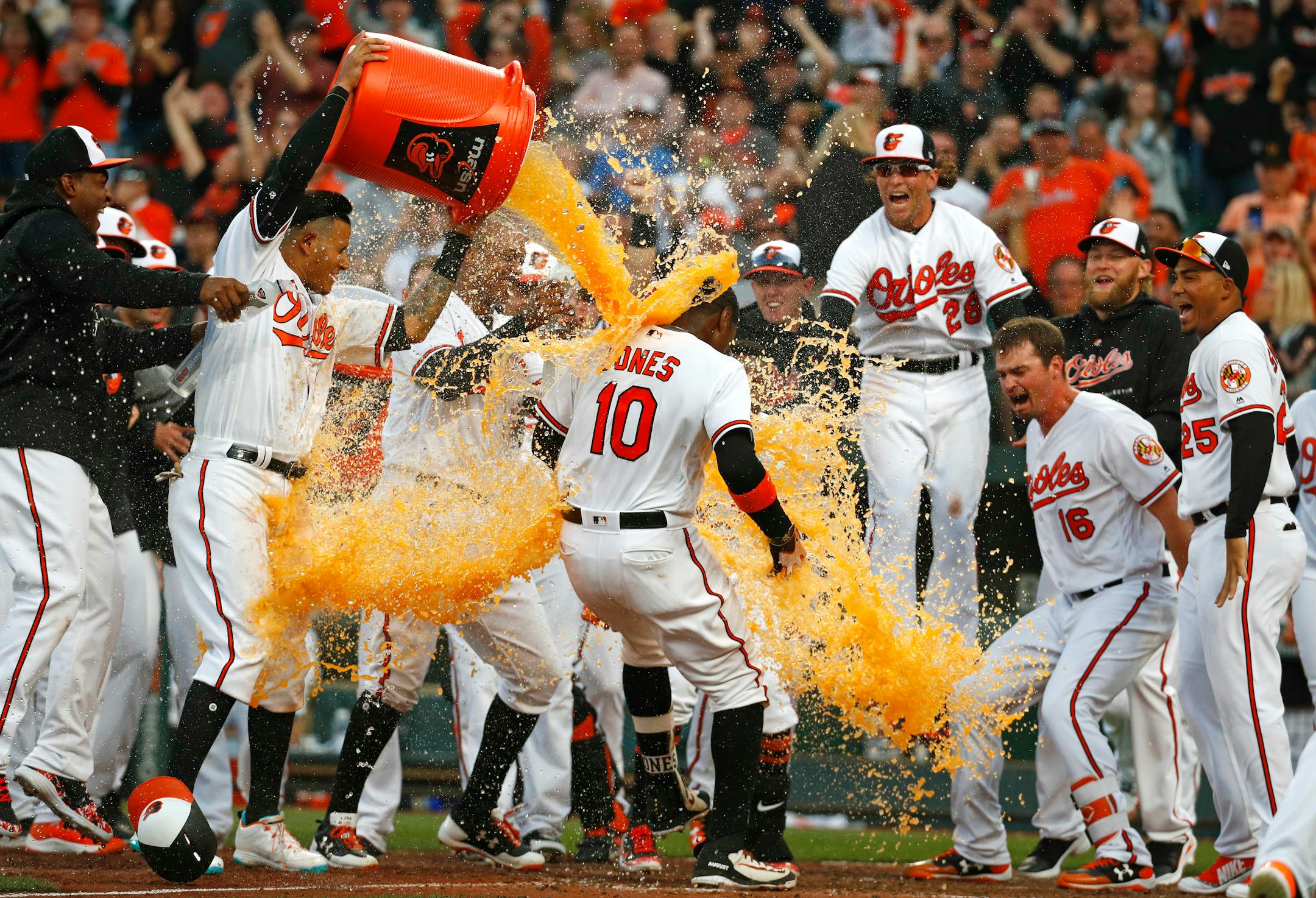 Teammates greeted the Orioles' Adam Jones (10) with a dousing at home plate after he hit a solo home run in the bottom of the 11th inning to beat the Twins 3-2 at Camden Yards on Thursday.