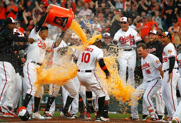Teammates greeted the Orioles' Adam Jones (10) with a dousing at home plate after he hit a solo home run in the bottom of the 11th inning to beat the 