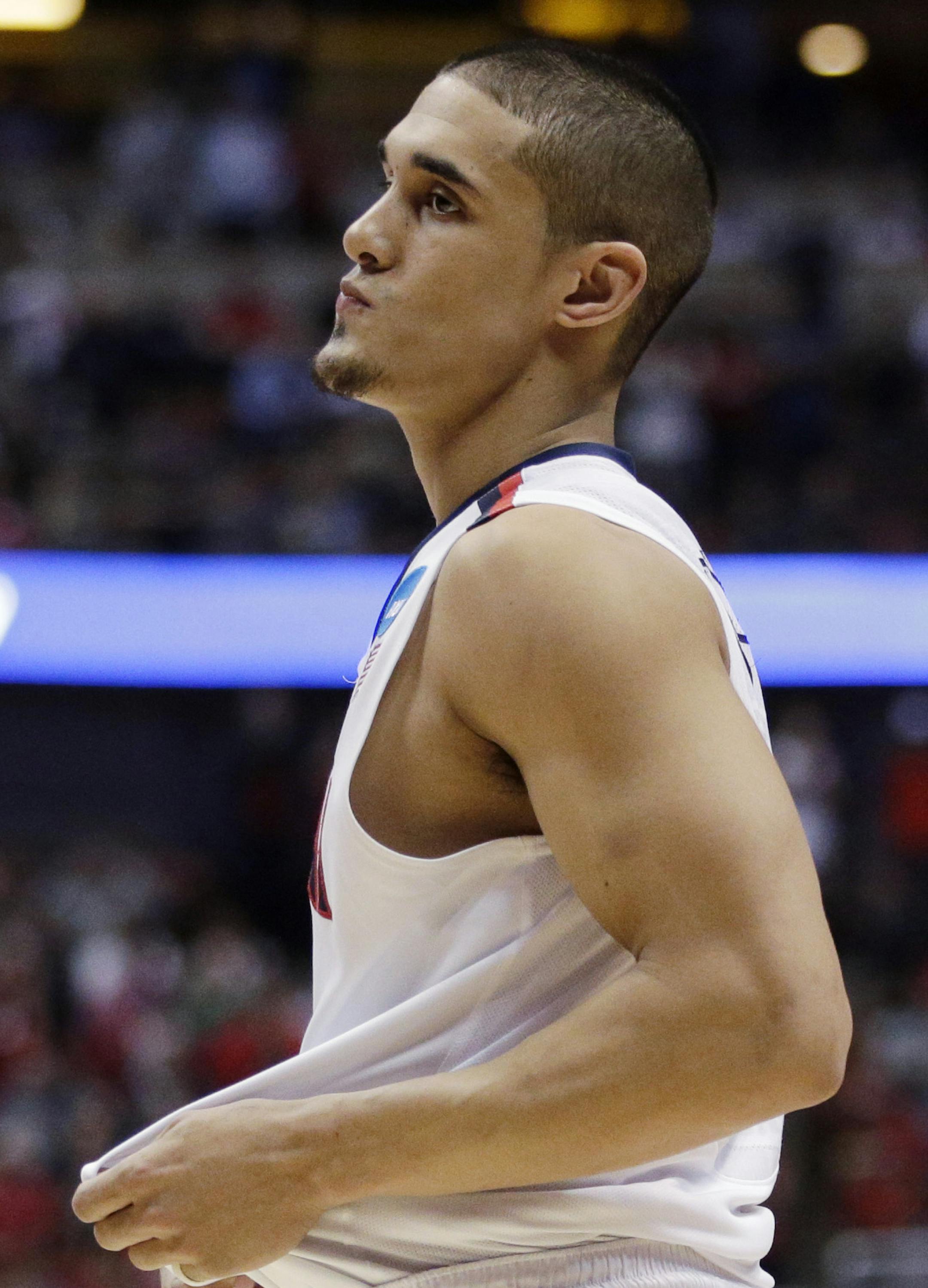 Arizona's Nick Johnson reacts as Wisconsin celebrates after overtime in a regional final NCAA college basketball tournament game, Saturday, March 29, 2014, in Anaheim, Calif. Wisconsin won 64-63 in overtime. (AP Photo/Jae C. Hong)