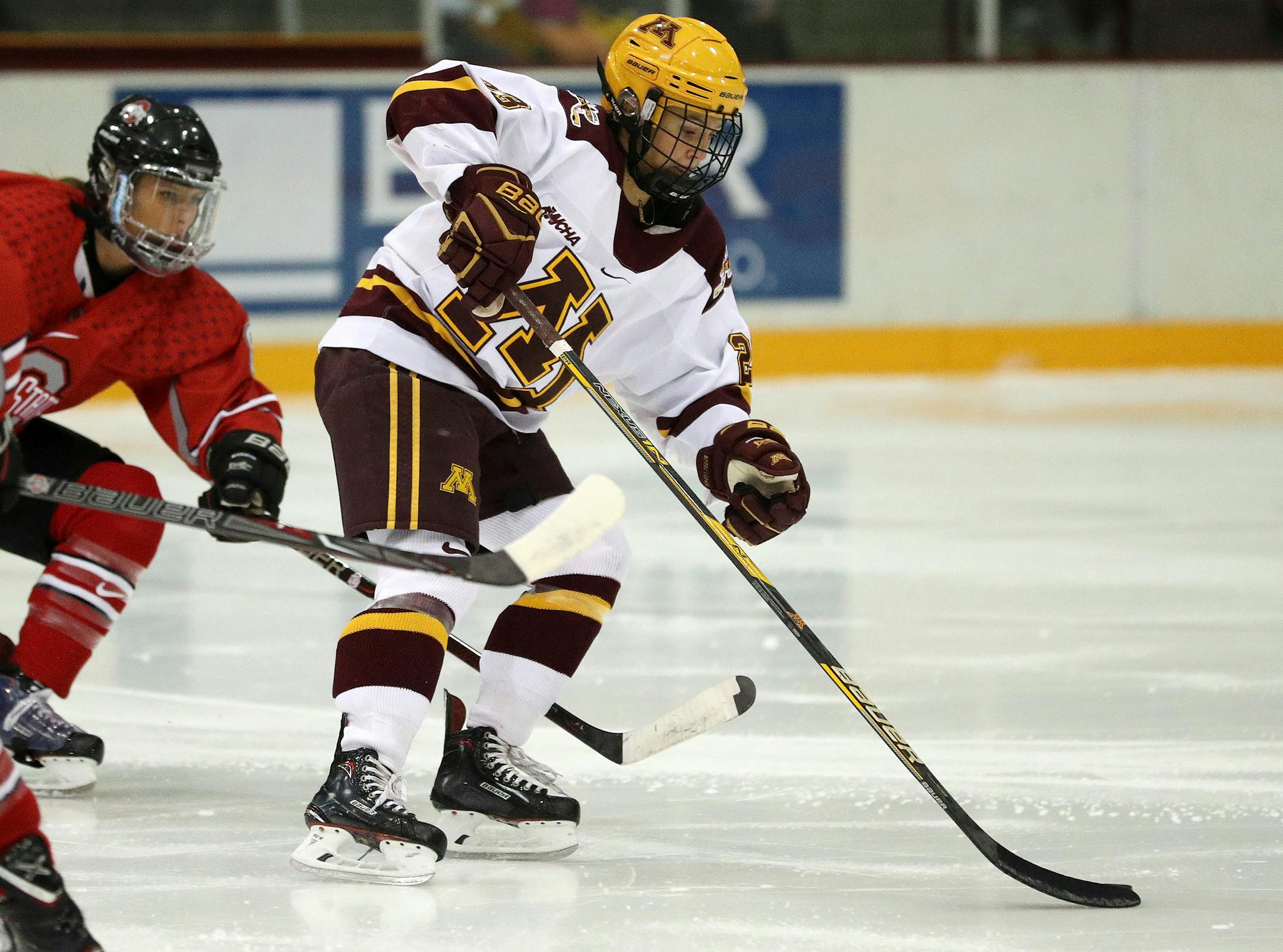 Minnesota forward Caitlin Reilly (23) moves the puck as Ohio State defenseman Dani Sadek (8) defends during the first period of an NCAA college hockey game Friday, Oct. 6, 2017, in Minneapolis. (Anthony Souffle/Star Tribune via AP)
